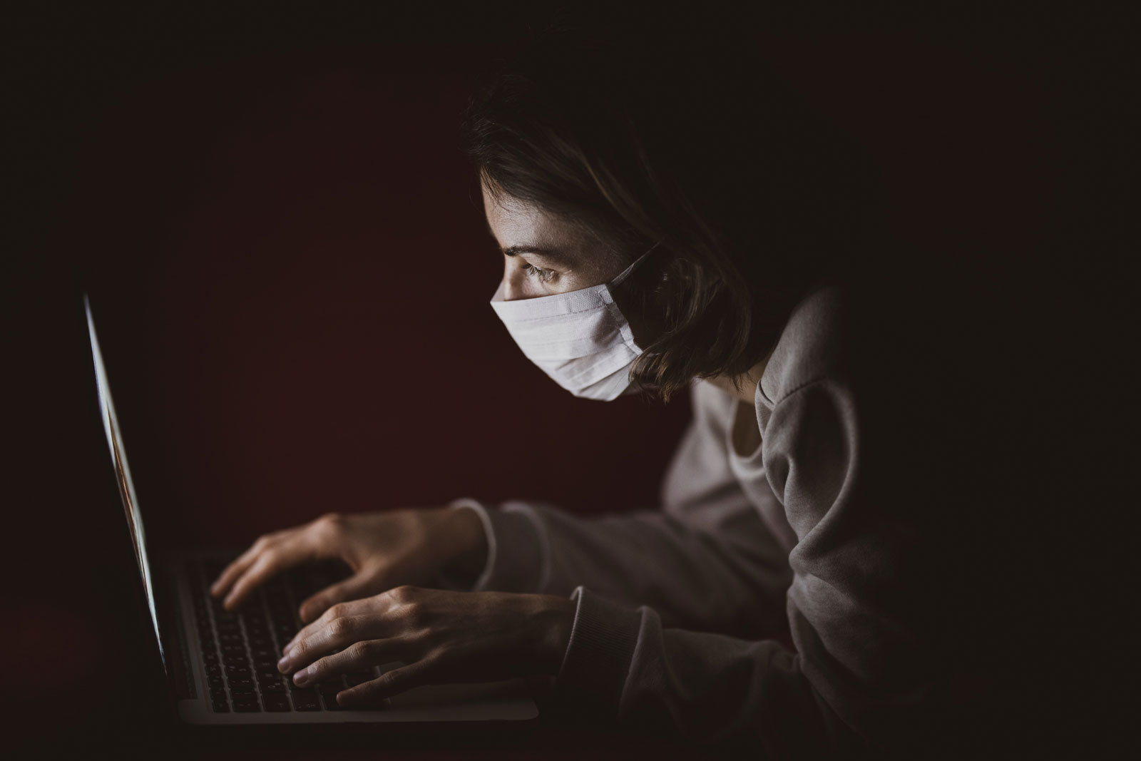 pessoa acessando o computador utilizando máscara buscando inovação durante a pandemia de coronavírus